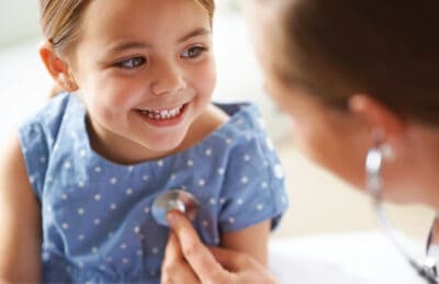 Kinderarzt behandelt ein kleines Mädchen
